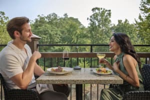 Couple having a scenic dinner outside at Between the Trees in Greenville
